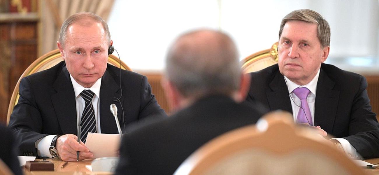 Vladimir Putin and Presidential Aide Yury Ushakov seated at table during sixth meeting of the High-Level Russian-Turkish Cooperation Council.