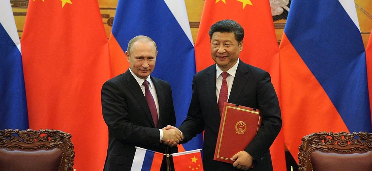 Xi Jinping and Putin shake hands