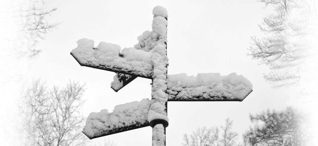 Snow-covered signposts pointing in different directions.