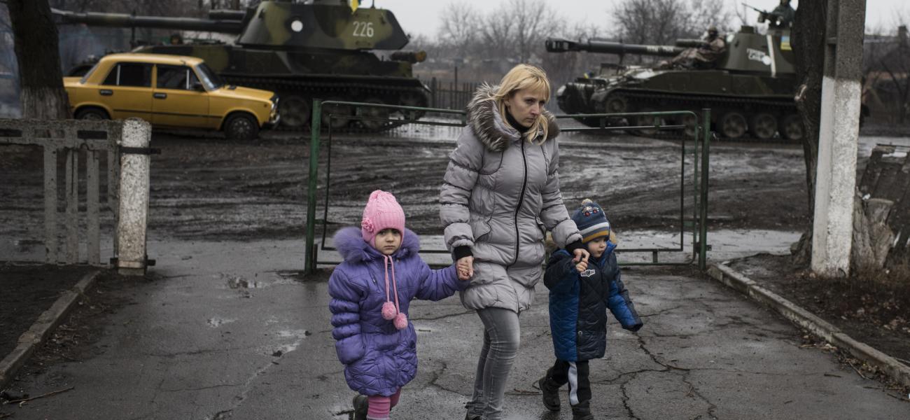 Eastern Ukraine, March 2015: A woman walking with two small children.