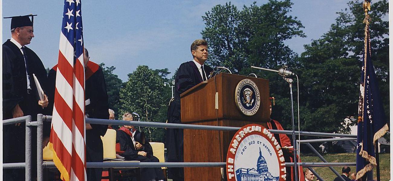 President John F. Kennedy at podium addresses American University Commencement, having received an honorary degree.