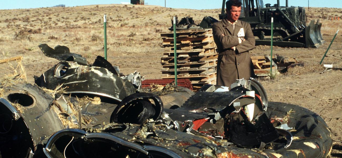 A Soviet inspector standing beside the mangled remnants of two Pershing II missile stages being destroyed under the INF Treaty, 1989.