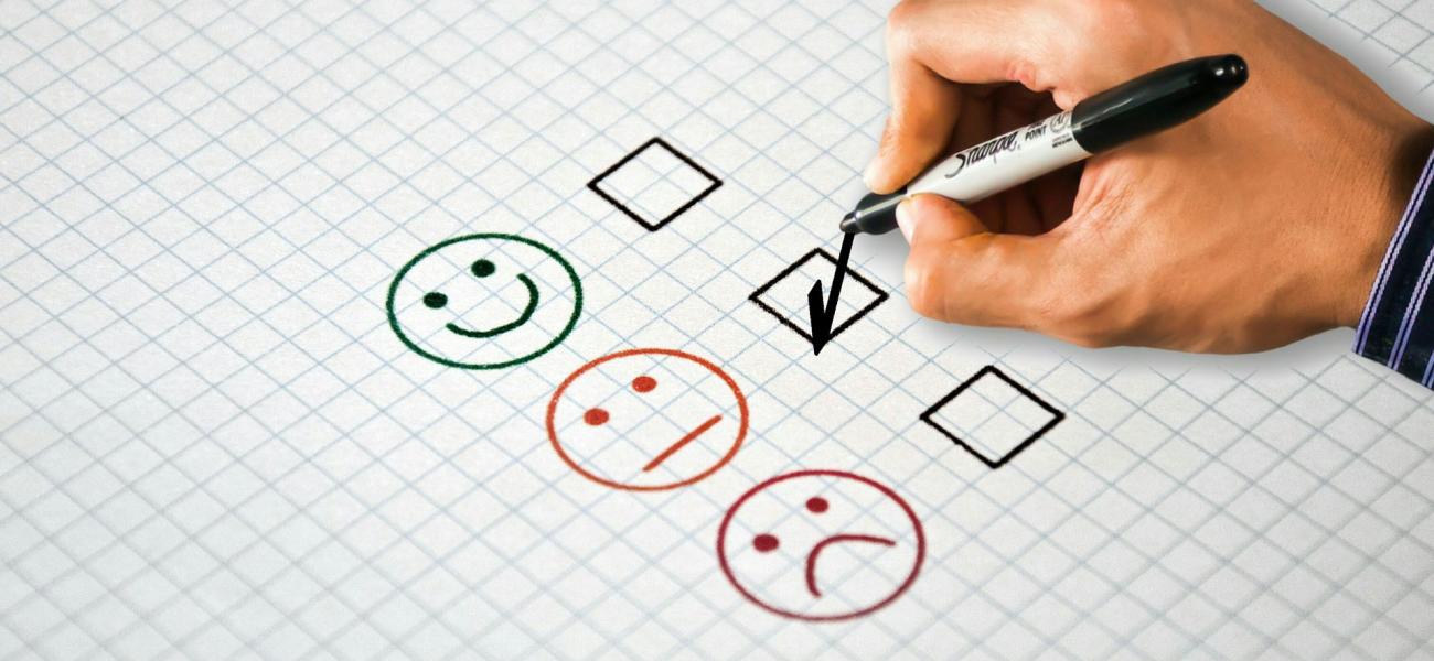 A poll with a happy face, neutral face and a sad face where someone is checking off the box next to the neutral face.